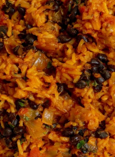 Bowl of black beans and rice garnished with cilantro and lime