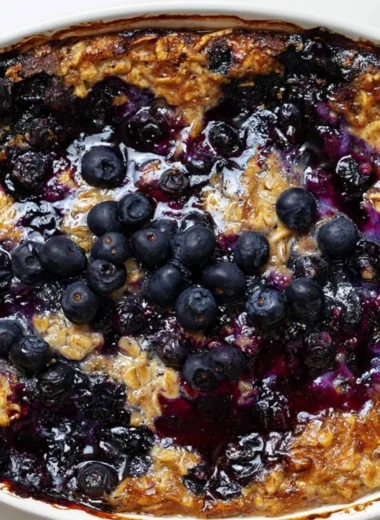 Delicious blueberry baked oatmeal in a dish, topped with fresh blueberries.