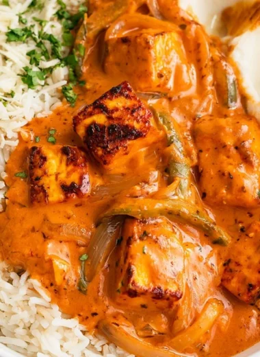 A delicious plate of Cottage Cheese Tikka Curry garnished with fresh herbs.