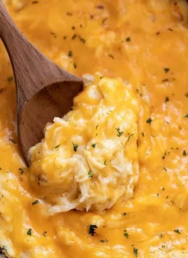 Delicious crockpot cheesy potatoes topped with melted cheese and herbs