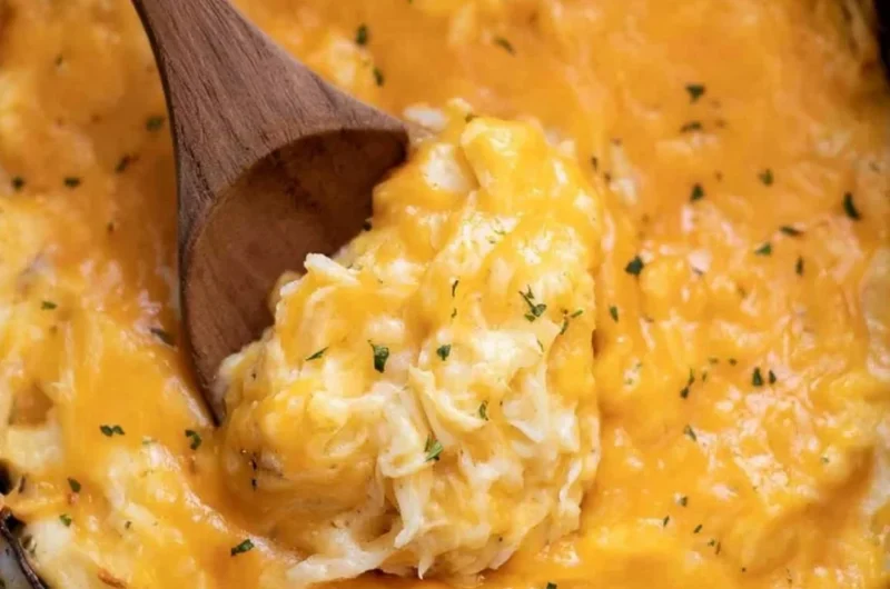 Delicious crockpot cheesy potatoes topped with melted cheese and herbs