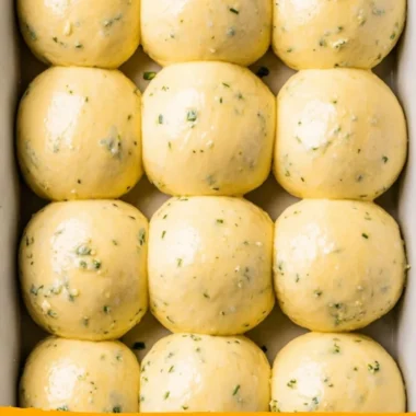 Freshly baked garlic bread rolls served warm on a wooden table