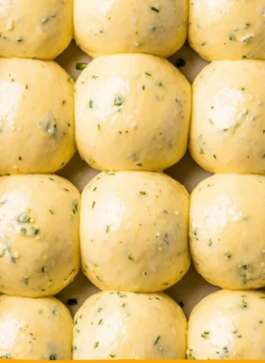 Freshly baked garlic bread rolls served warm on a wooden table