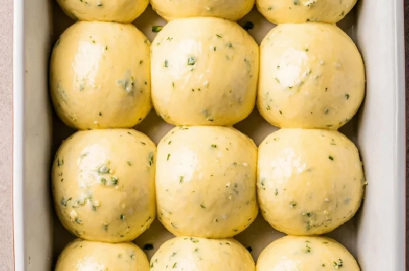 Freshly baked garlic bread rolls served warm on a wooden table