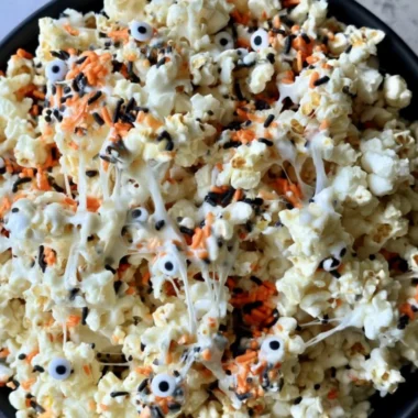 Bowl of colorful Halloween popcorn with spooky decorations