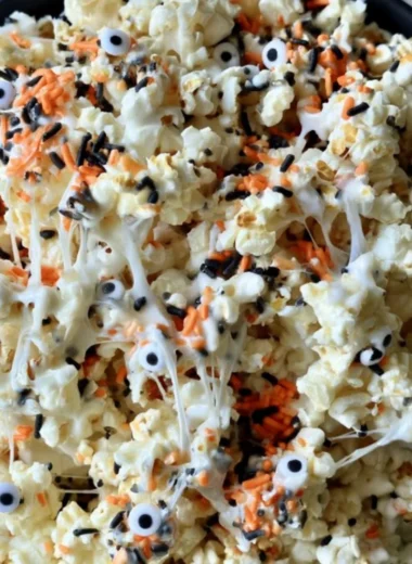 Bowl of colorful Halloween popcorn with spooky decorations