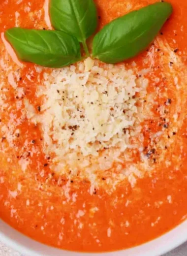 High protein tomato soup served in a bowl with fresh ingredients