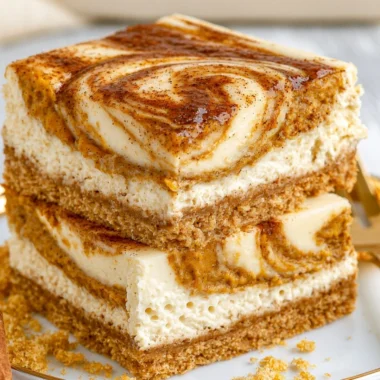 Delicious pumpkin cheesecake bars served on a rustic wooden table.