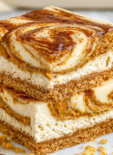 Delicious pumpkin cheesecake bars served on a rustic wooden table.
