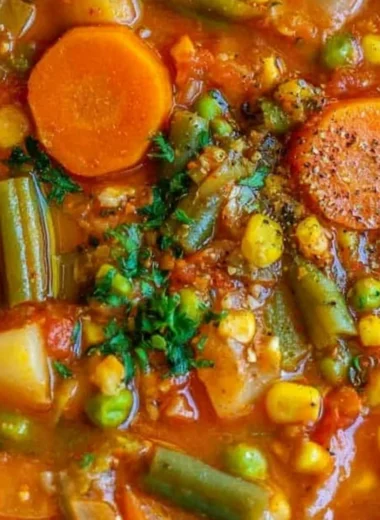 A bowl of colorful, healthy vegetable soup with fresh ingredients.
