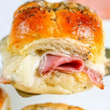 Baked ham and cheese sliders on a platter, perfect for appetizers and snacks