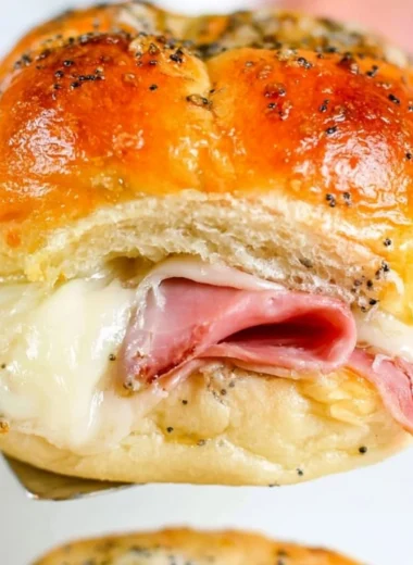 Baked ham and cheese sliders on a platter, perfect for appetizers and snacks