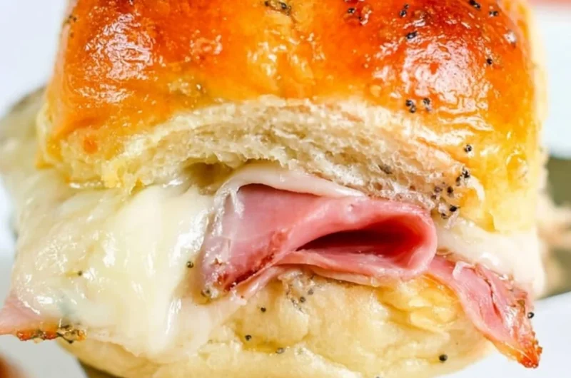 Baked ham and cheese sliders on a platter, perfect for appetizers and snacks