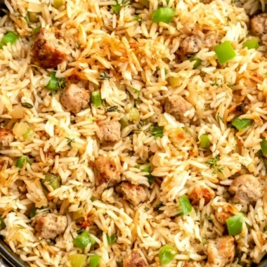 Plate of Cajun dirty rice with sausage garnished with green onions.
