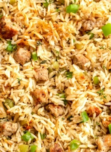 Plate of Cajun dirty rice with sausage garnished with green onions.