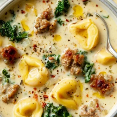 Bowl of creamy sausage tortellini soup garnished with herbs