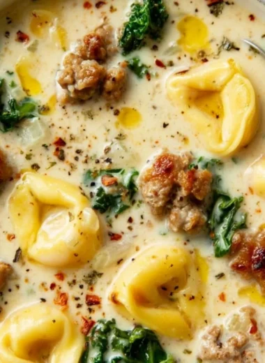 Bowl of creamy sausage tortellini soup garnished with herbs