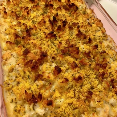 Easy chicken dressing casserole served in a baking dish with fresh herbs