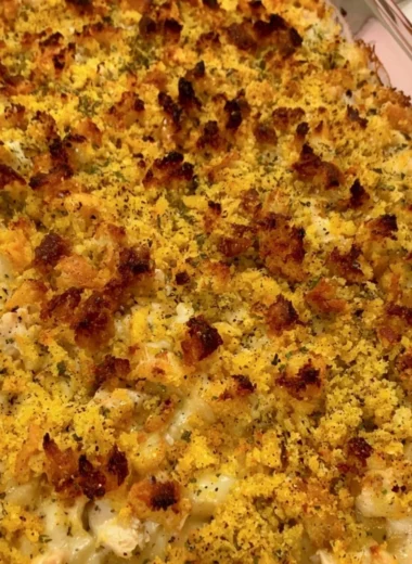 Easy chicken dressing casserole served in a baking dish with fresh herbs