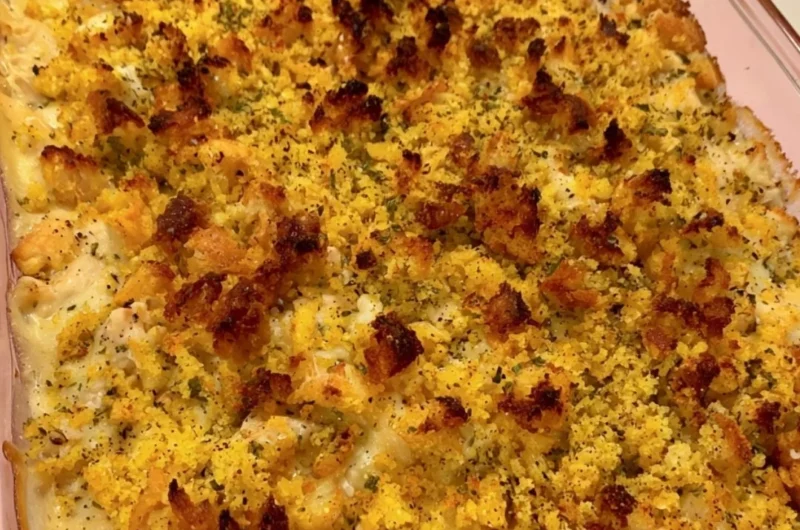 Easy chicken dressing casserole served in a baking dish with fresh herbs