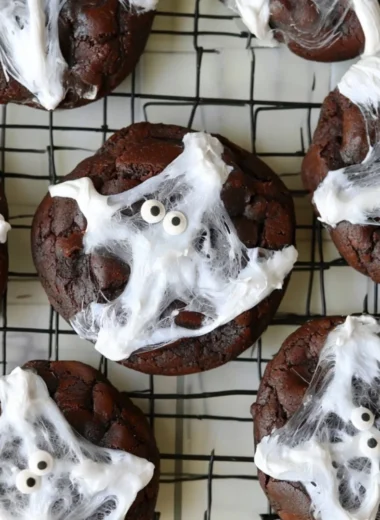 Halloween double chocolate spider web cookies on a spooky-themed plate
