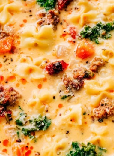 Delicious Italian sausage pasta soup in a bowl with fresh herbs and spices.
