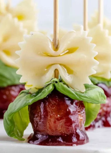 Bowtie pasta and cocktail meatball skewers served on a platter.