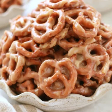 Delicious caramel pretzels drizzled with chocolate on a rustic wooden background