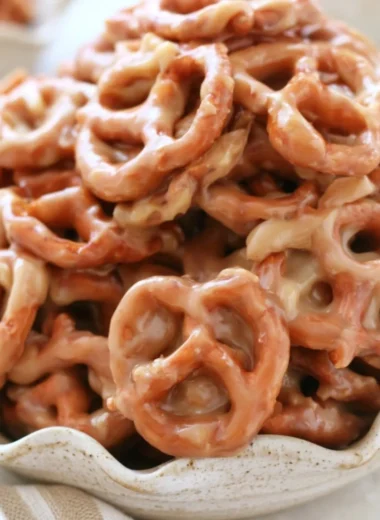 Delicious caramel pretzels drizzled with chocolate on a rustic wooden background