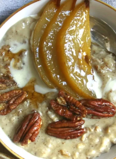 Chai Spiced Pear Porridge topped with fresh spices and pears in a ceramic bowl