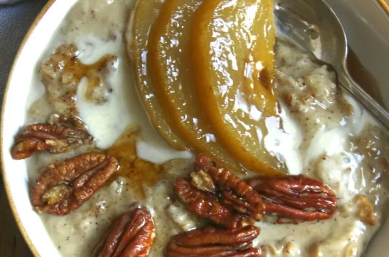 Chai Spiced Pear Porridge topped with fresh spices and pears in a ceramic bowl
