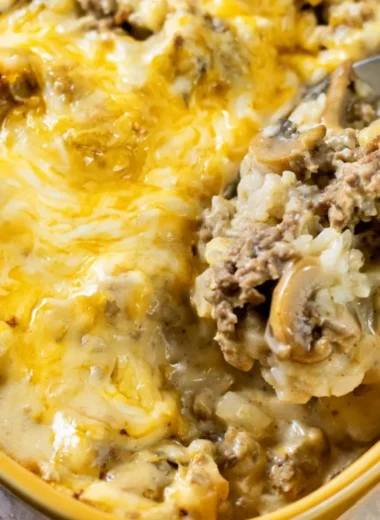 Cheesy Ground Beef and Rice Casserole in a baking dish topped with melted cheese