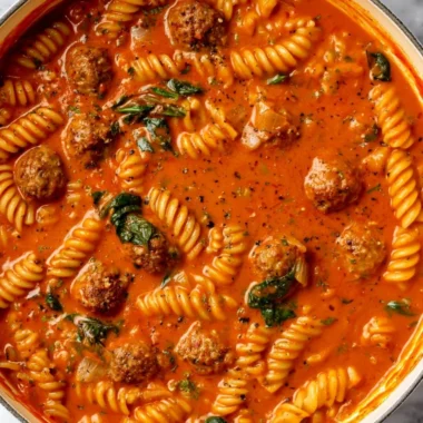 Bowl of creamy Italian meatball soup with fresh herbs and ingredients