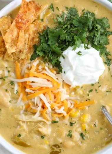 Bowl of easy green enchilada chicken soup with toppings and green chilies
