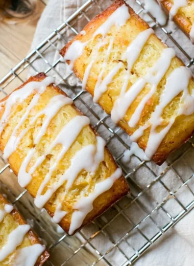 Slice of homemade Eggnog Bread drizzled with Sugar Rum Glaze on a festive table.