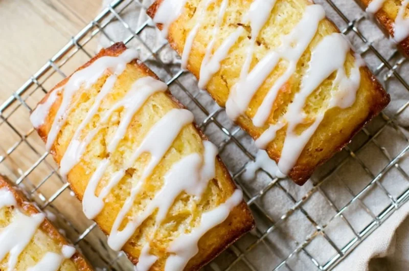 Slice of homemade Eggnog Bread drizzled with Sugar Rum Glaze on a festive table.